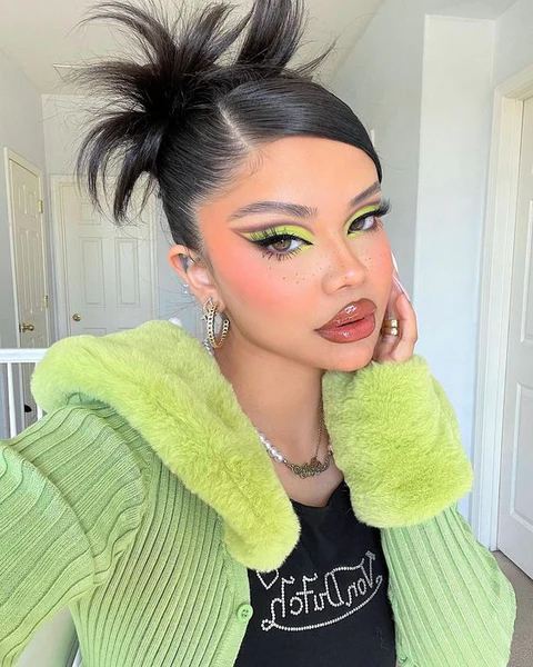 Y2K inspired space bun prom hairstyle with glitter accents and sleek edges