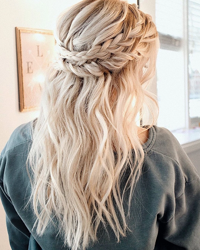 Boho braided wedding hair styled with loose waves and floral accents