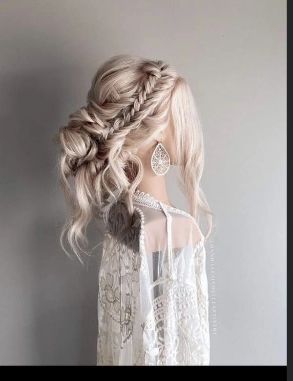 Boho braided wedding hair styled with loose waves and delicate floral accents