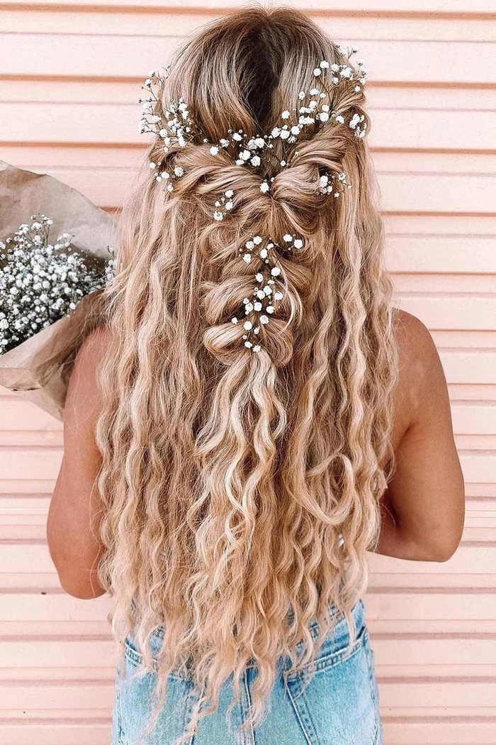 Boho braided wedding hair styled with soft, loose braids adorned with delicate floral accents