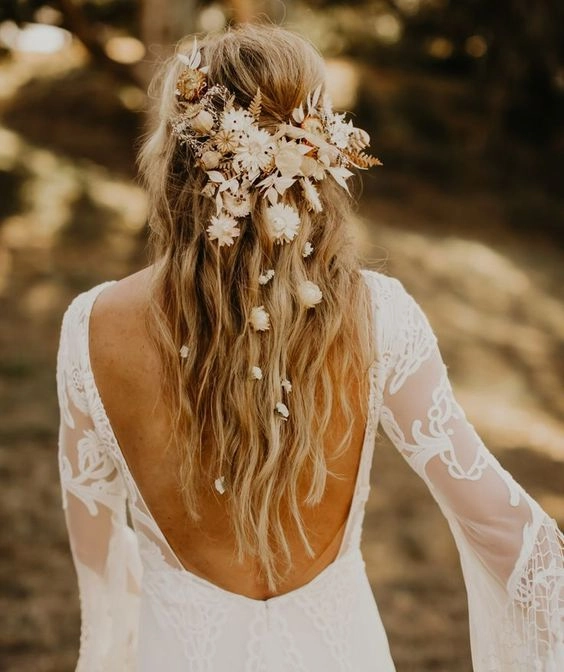 Boho braided wedding hair styled with loose waves and floral accents