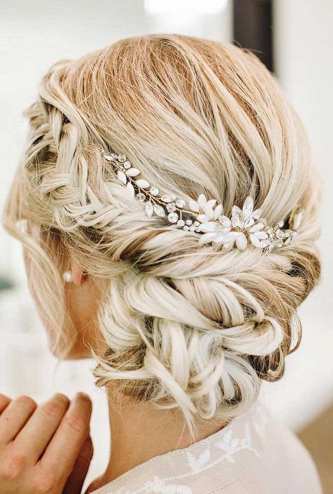 Boho braided wedding hair styled with loose waves and floral accents