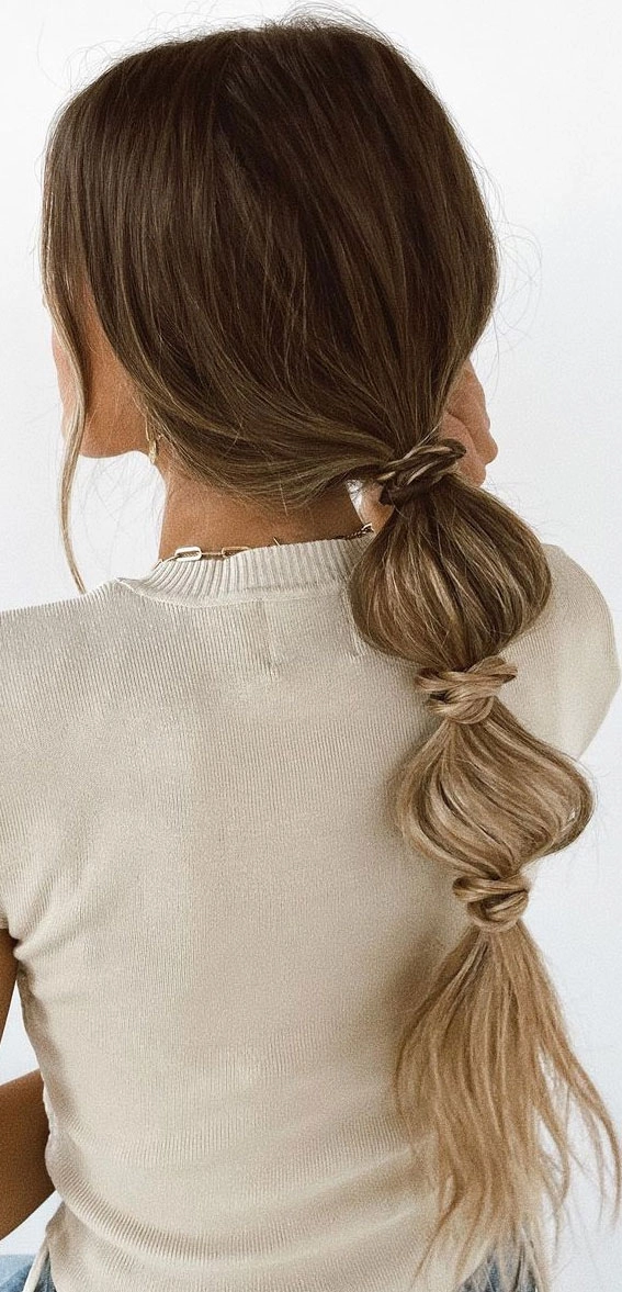 Elegant bridal hair bubble ponytail styled with soft curls for a wedding