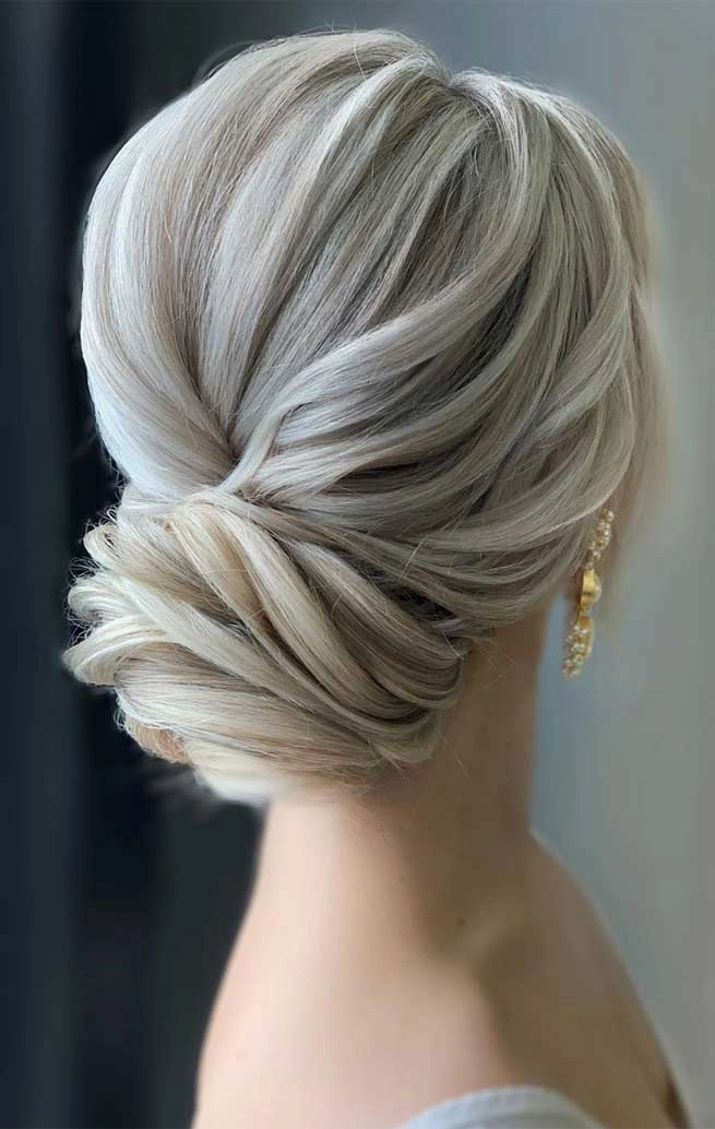Elegant bridal hair for gray hair styled in soft waves with floral accents