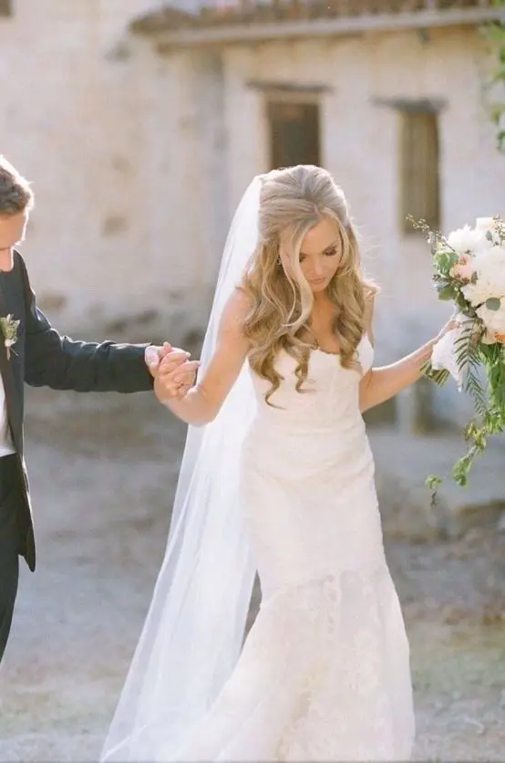Stunning wedding hairstyle with cathedral veil perfect for a timeless bridal look Elegant bridal hairstyle featuring a cathedral veil flowing over soft curls