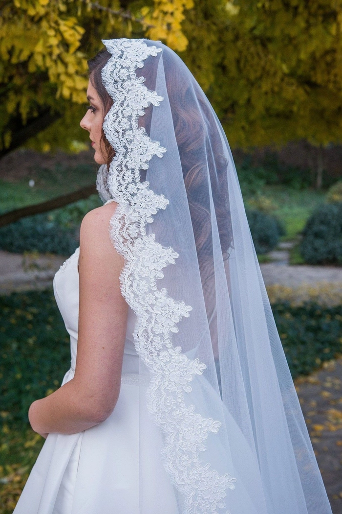 Classic bridal hairstyle with a cathedral veil perfect for a formal wedding look Elegant bridal hairstyle featuring a cathedral veil with soft curls and floral accents