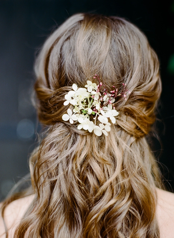 Elegant wedding hairstyle featuring bridal hair with fresh flowers and soft curls Bridal hairstyle adorned with fresh flowers for a romantic wedding look