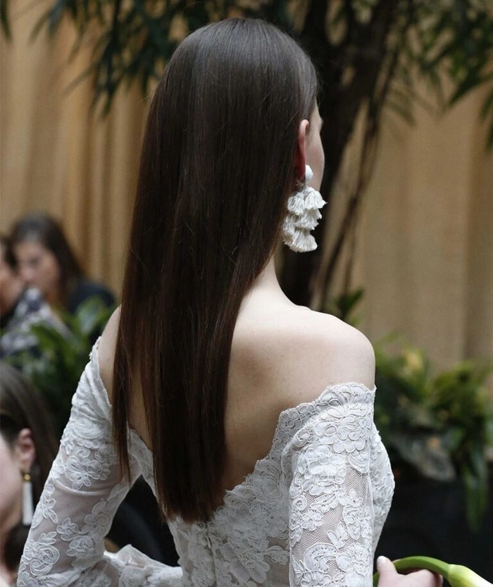 Bridal hairstyle featuring long straight sleek hair for a modern wedding look