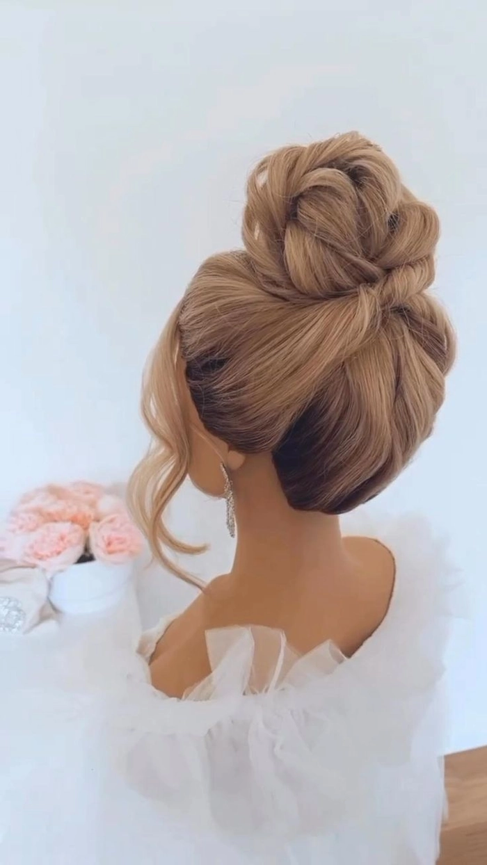 Elegant bridal top knot bun showcasing a chic wedding hairstyle idea Elegant bridal top knot bun hairstyle perfect for modern weddings