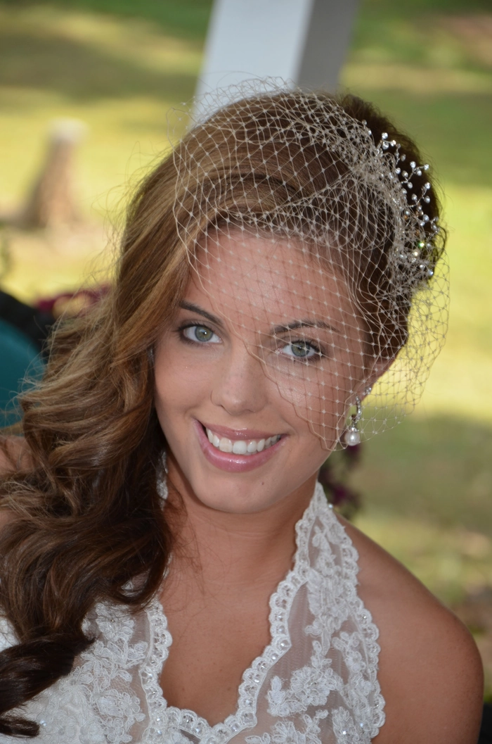 Elegant bridal updo featuring wedding hairstyles with a birdcage veil