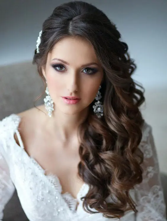 Side swept curls hairstyle perfect for wedding celebrations Bride with elegant wedding hair side swept curls styled for a special day
