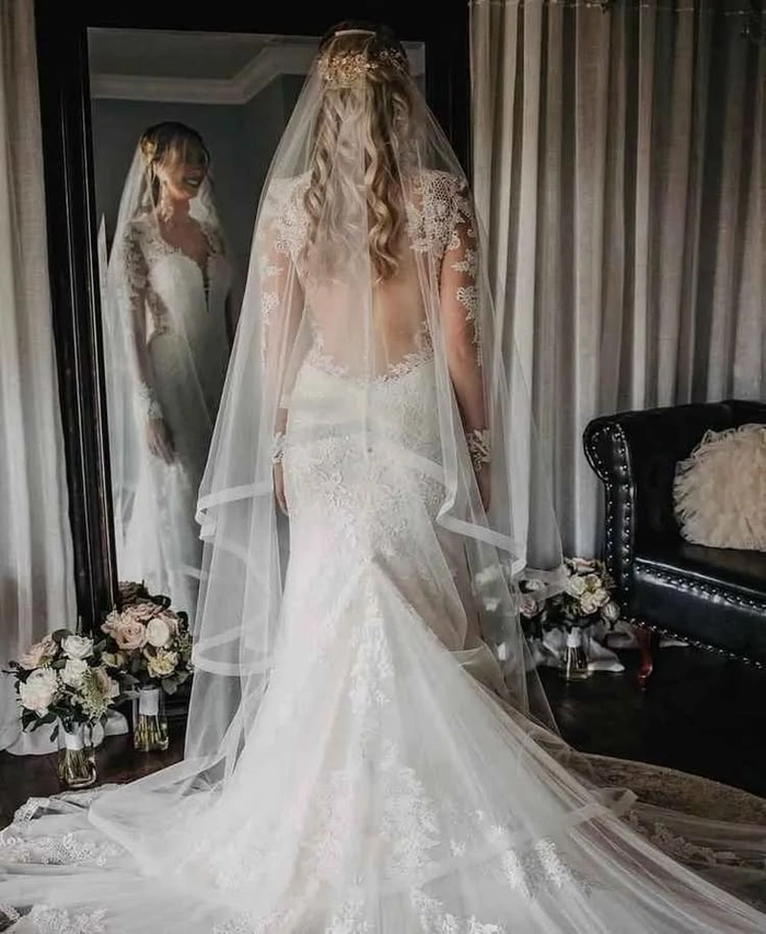 Elegant bridal hairstyle featuring long waves and a flowing veil Bride with long wavy wedding hair wearing a delicate veil
