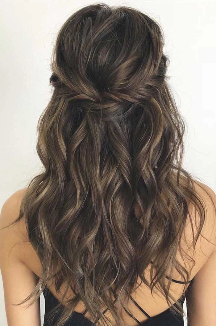Stylish bridesmaid half up half down hairstyle perfect for wedding celebrations Bridesmaid with elegant half up half down hairstyle adorned with floral accessories