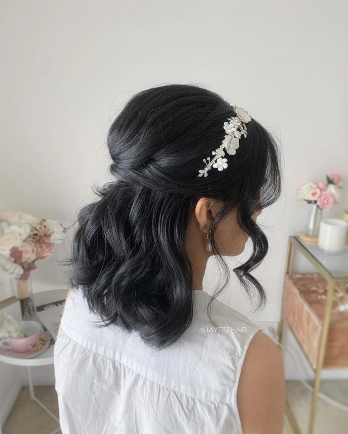 Beautiful bridal party hairstyle showcasing a romantic half up half down look Bridesmaid with elegant half up half down hairstyle featuring loose curls