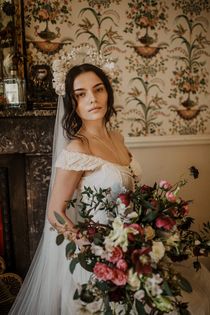 Elegant Edwardian wedding updo featuring intricate curls and delicate floral accents