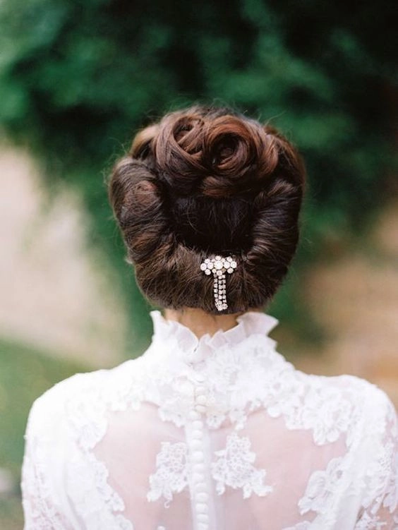 Elegant Edwardian wedding updo featuring intricate curls and vintage accessories