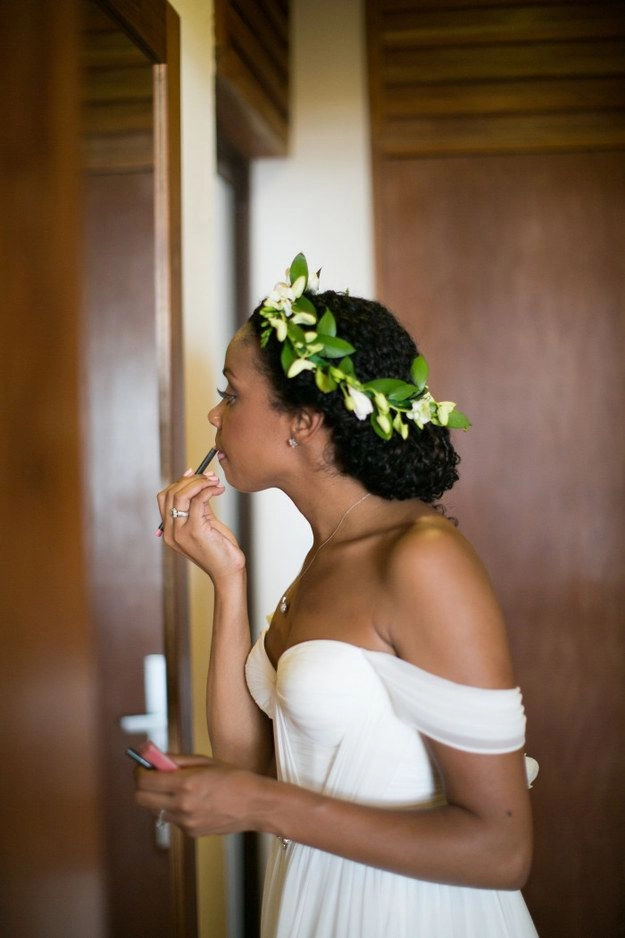 Elegant natural black hair bridal look featuring soft curls and floral accents