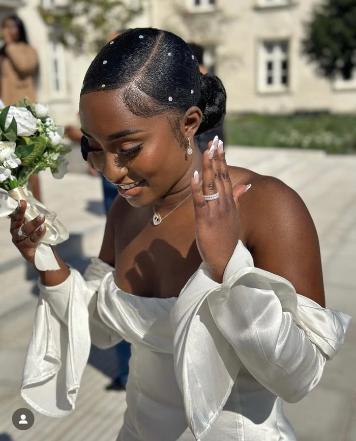Elegant natural black hair bridal look with soft curls and floral accessories