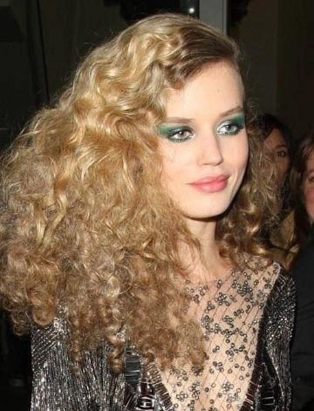 Elegant bridal hairstyle inspired by the disco era with voluminous curls and sparkle
