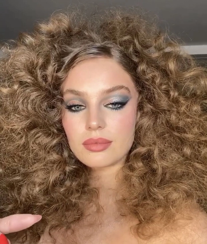Elegant bridal hairstyle inspired by the disco era with voluminous curls