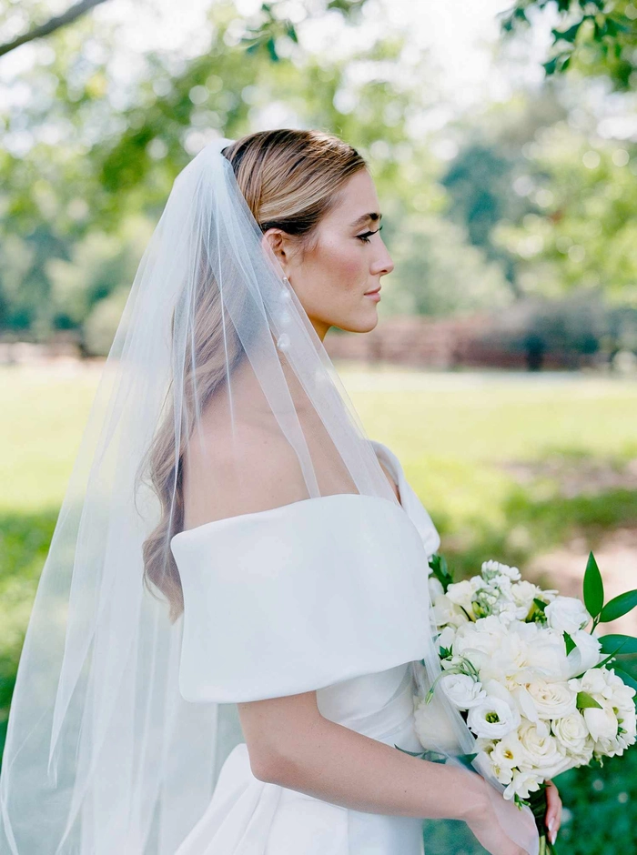 Elegant bridal hair styled for an off the shoulder wedding dress
