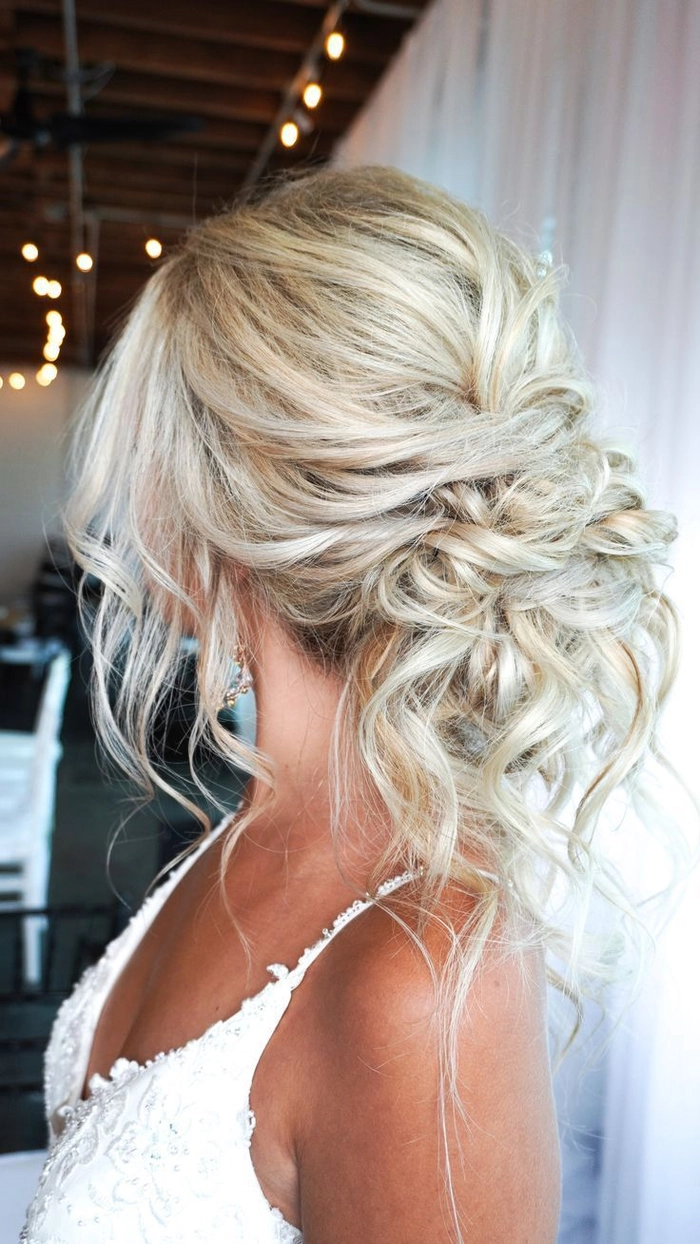 Romantic wedding hairstyle idea for elopement brides with delicate flowers Elegant elopement bridal hair style featuring soft curls and floral accents