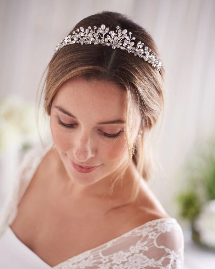 Beautiful bridal look with wedding hair styled alongside a crystal tiara accessory Elegant wedding hairstyle featuring a bride wearing a sparkling crystal tiara