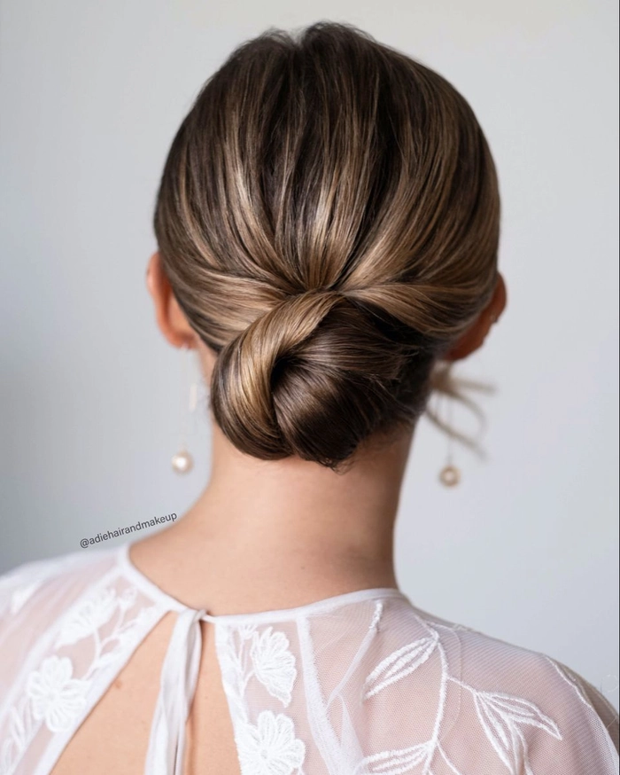 Chic wedding hairstyle featuring a low bun and soft face framing strands for brides Elegant bridal low bun with delicate face framing pieces for a romantic wedding look