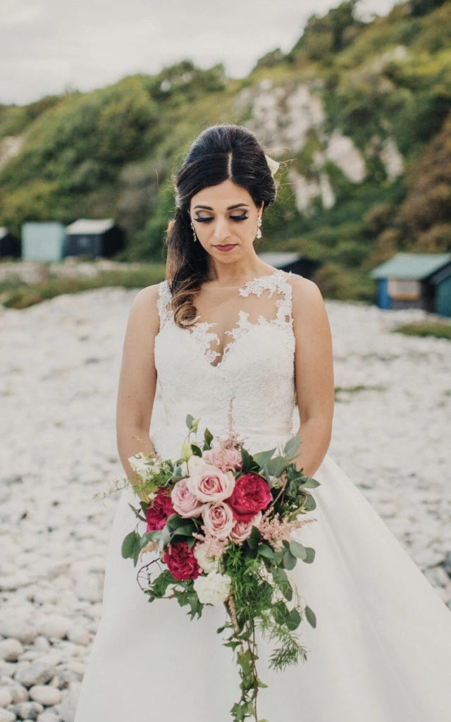 Elegant bridal hair styled with soft waves for an off the shoulder wedding dress
