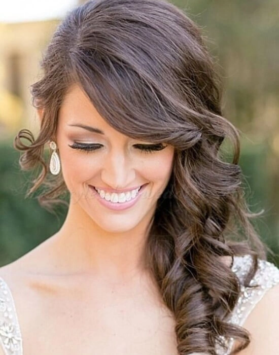 Beautiful side swept curls hairstyle perfect for a romantic wedding look Elegant bride with wedding hair side swept curls and delicate floral accessories