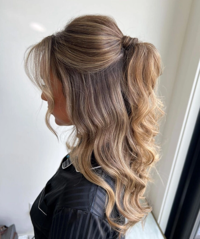 Bridesmaid half up half down styles perfect for wedding day elegance and charm Elegant bridesmaid showcasing a half up half down hairstyle with soft waves and floral accents
