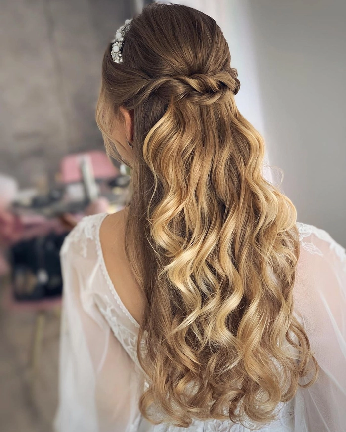 Elegant bridesmaid hairstyle for long hair with soft curls and floral accents