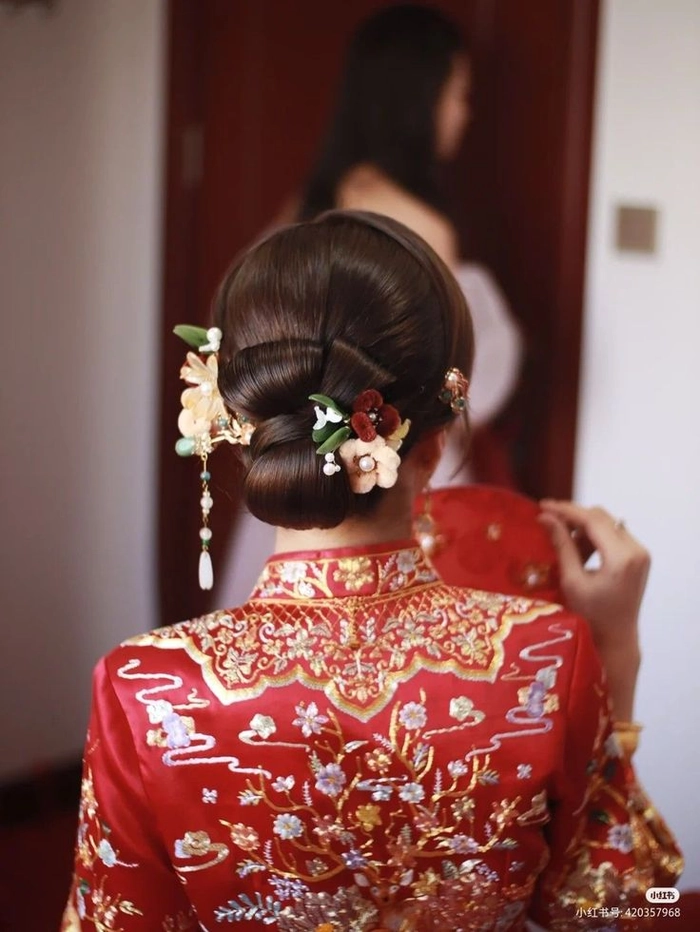 Elegant Chinese wedding hair styled with decorative hair sticks for traditional bridal look