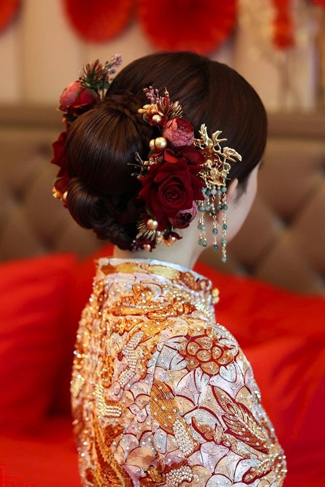 Elegant Chinese wedding hair styled with traditional hair sticks and floral accents