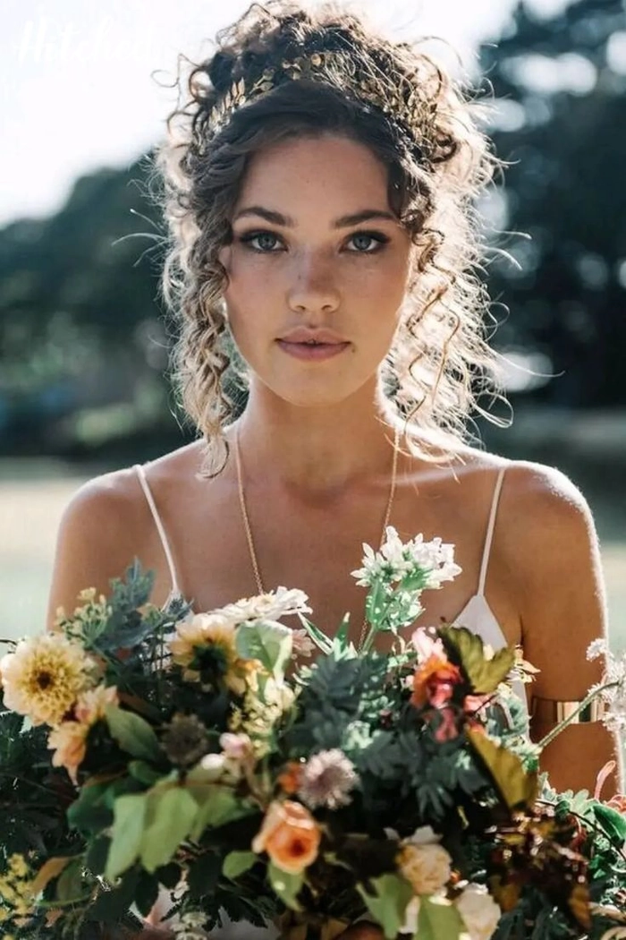 Elegant bridesmaid hair for curly hair styled with soft curls and accessories