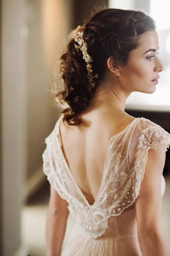 Elegant Edwardian wedding updo with intricate curls and floral accents