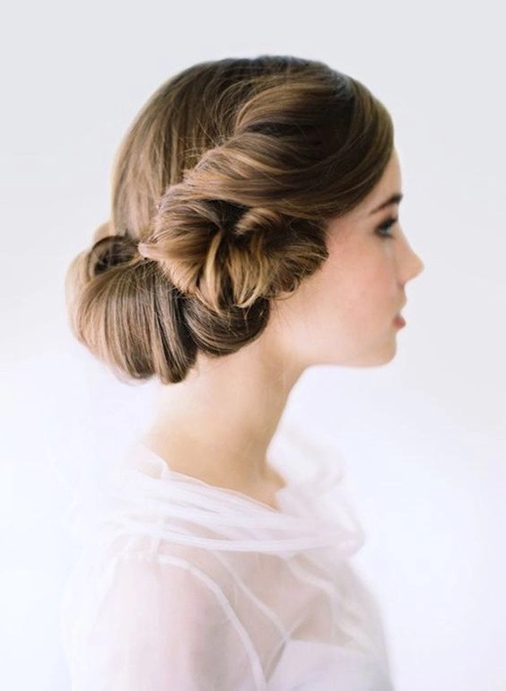 Elegant Edwardian wedding updo featuring intricate curls and delicate floral accents