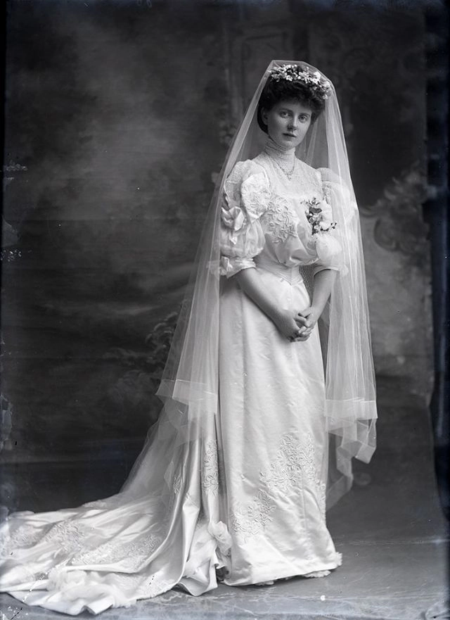 Elegant Edwardian wedding updo with intricate curls and delicate floral accents