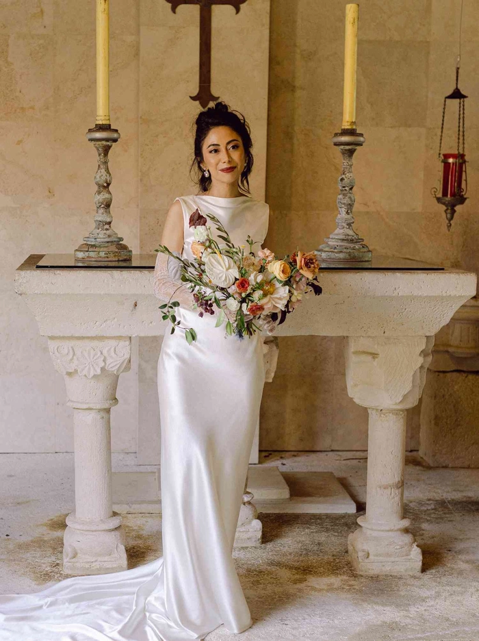 Elegant Edwardian wedding updo with intricate curls and delicate floral accents