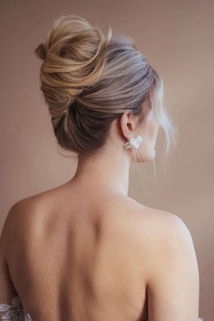 Elegant French twist bridal hair styled with delicate accessories for a wedding day