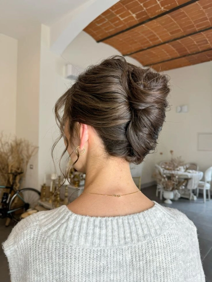 Elegant French twist bridal hair styled with soft curls and delicate accessories