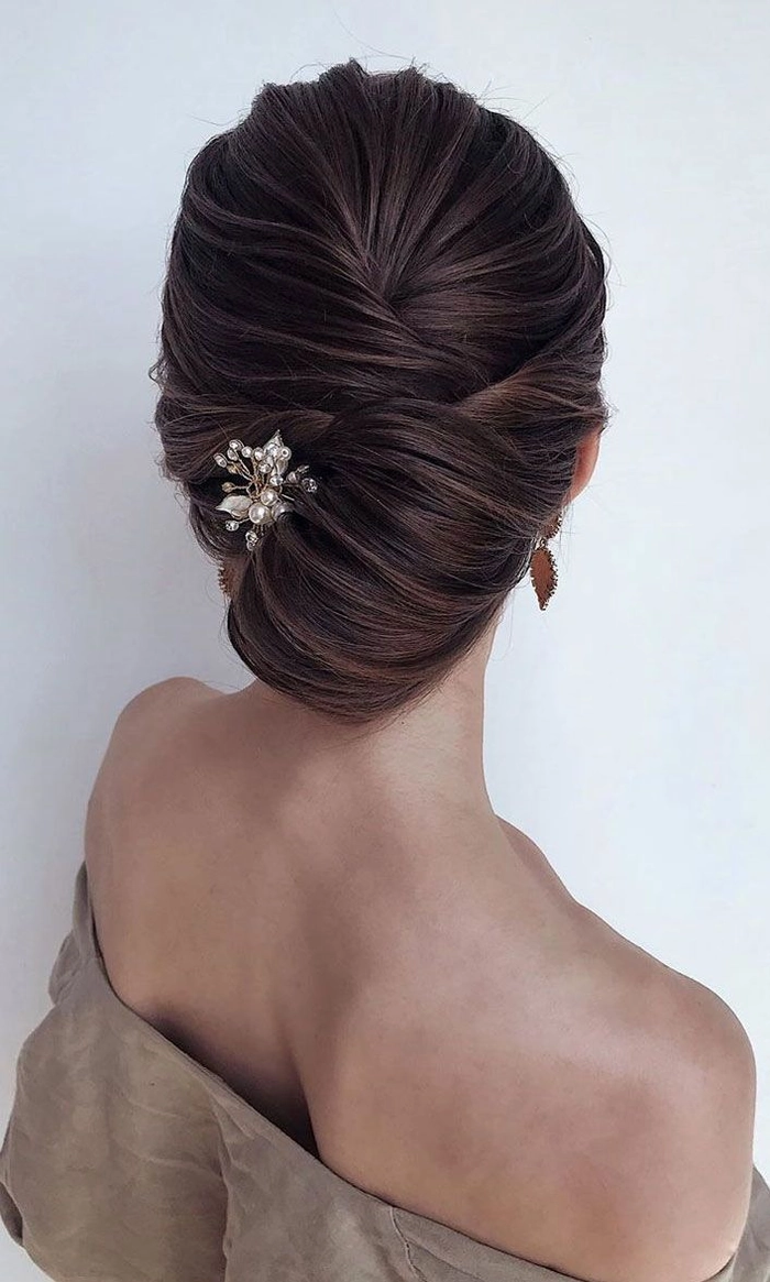 Elegant French twist bridal hair styled with delicate floral accents