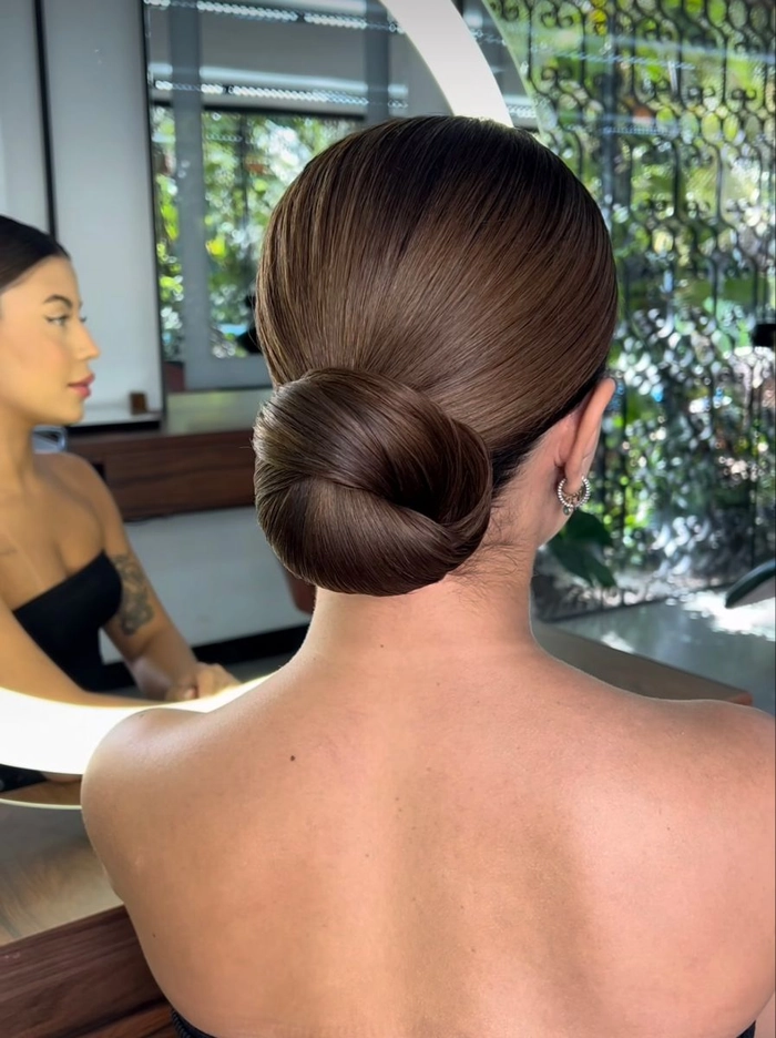 Sleek and simple bridal updo perfect for a contemporary wedding look Elegant modern minimalist bridal bun hairstyle with soft waves