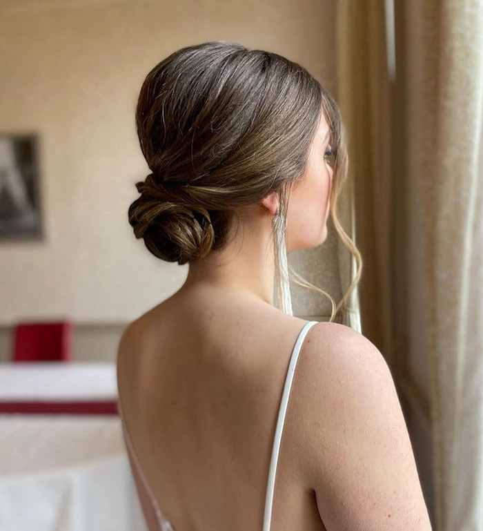 Chic modern minimalist bridal bun perfect for a wedding day look Elegant modern minimalist bridal bun hairstyle with sleek finish
