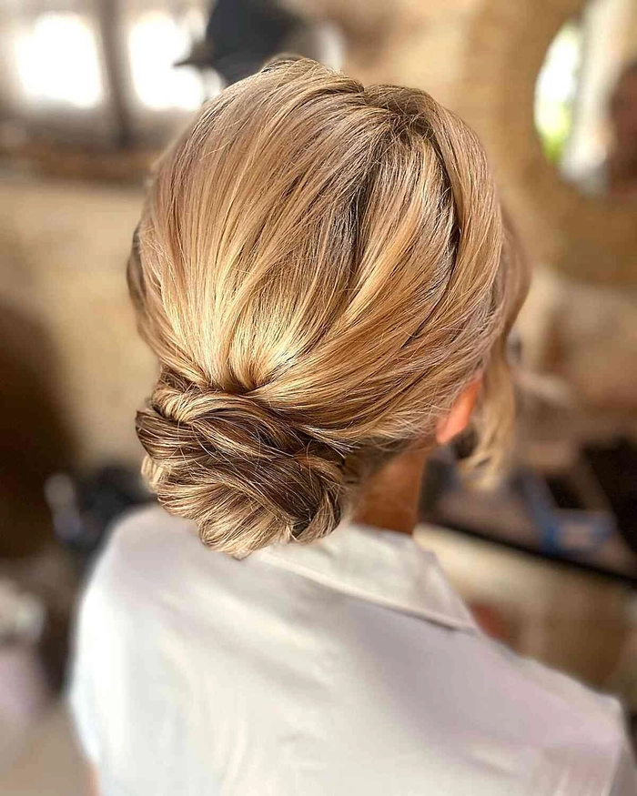 Chic and effortless summer wedding guest hairstyle inspiration Elegant summer wedding guest hair styled with soft waves and floral accessories