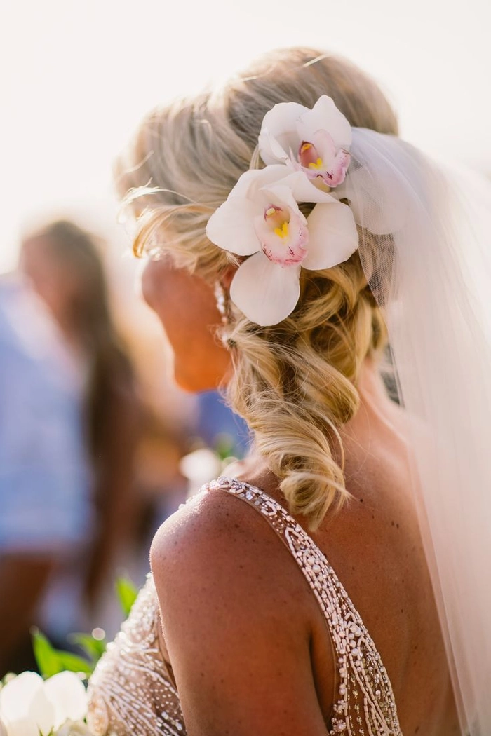 Destination tropical wedding hair styled for a perfect seaside celebration Elegant tropical wedding hairstyle with floral accessories for a beach ceremony