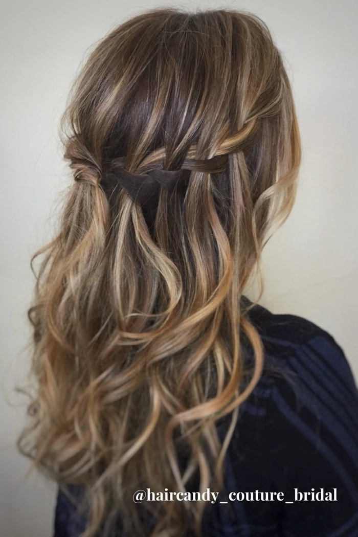Stunning wedding hairstyle featuring a beautifully crafted waterfall braid Elegant waterfall braid wedding hair with delicate floral accents