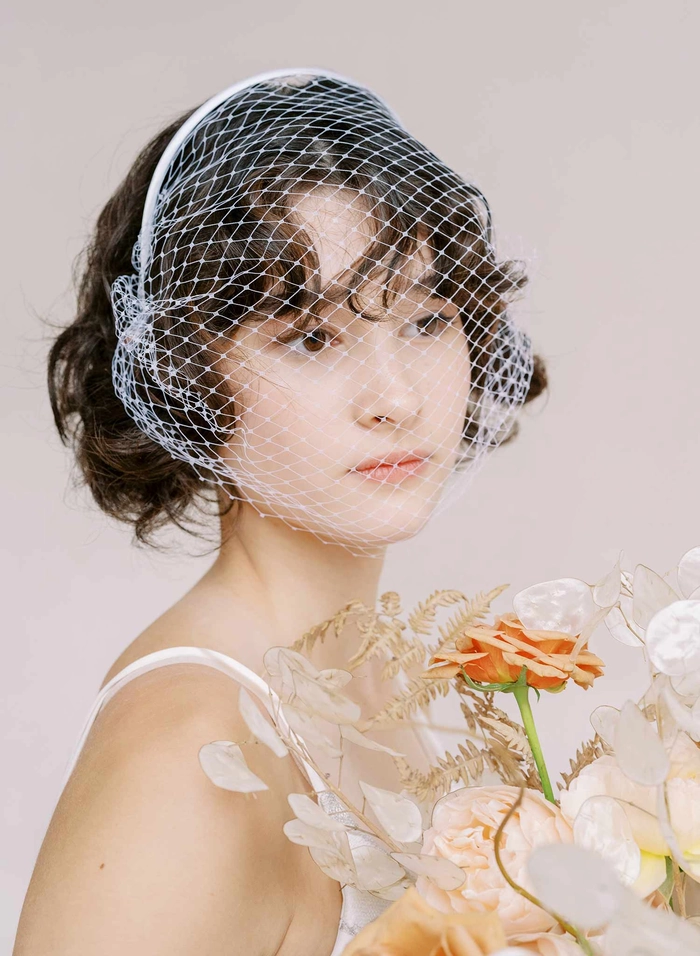 Elegant wedding hairstyle featuring a classic birdcage veil
