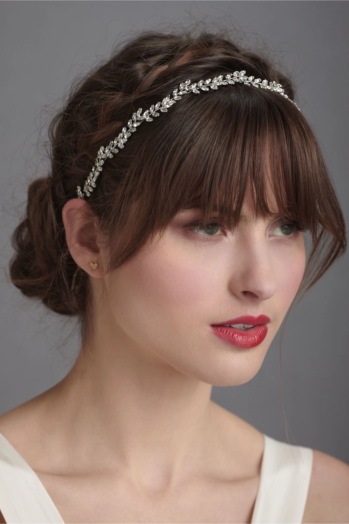 Elegant wedding hairstyle featuring soft bangs and a romantic updo