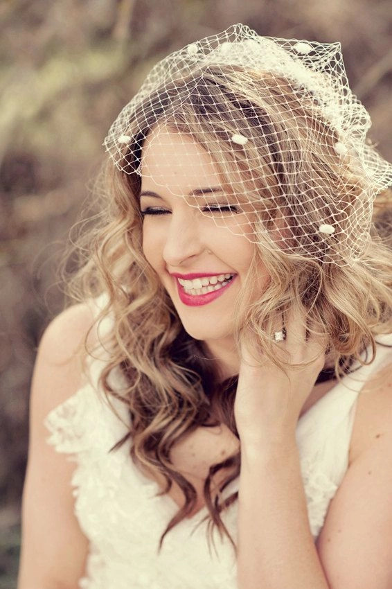 Elegant wedding hairstyles with a vintage-inspired birdcage veil and soft curls